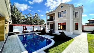 a house with a swimming pool in the yard at Qafqaz Resort Harmony in Gabala