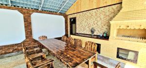 Zimmer mit einem Holztisch, Stühlen und einem Kamin in der Unterkunft Qafqaz Resort Harmony in Qəbələ