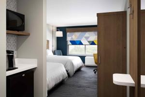 Holiday Inn Express & Suites - Phoenix West - Tolleson, an IHG Hotel في فينكس: غرفة فندقية بسريرين ونافذة
