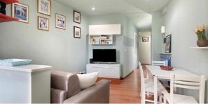ein Wohnzimmer mit einem Sofa und einem Tisch mit einem TV in der Unterkunft Nel blu dipinto di blu Apartment in Levanto