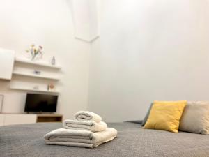 a pile of towels sitting on top of a bed at La casa di Nina in Surano +19 photos