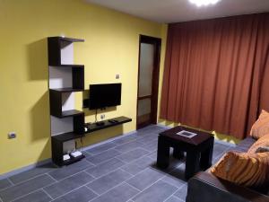 ein Wohnzimmer mit einem Sofa und einem Flachbild-TV in der Unterkunft Eli Apartment in Burgas City