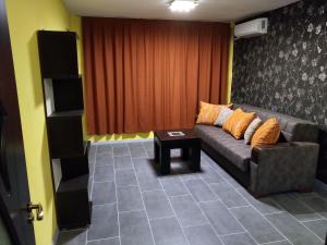 ein Wohnzimmer mit einem Sofa und einem Tisch in der Unterkunft Eli Apartment in Burgas City