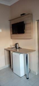 eine Küche mit einem Tisch, einem Kühlschrank und einem TV in der Unterkunft Hlalakahle Lodge in Glencoe