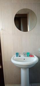 ein Badezimmer mit einem weißen Waschbecken und einem Spiegel in der Unterkunft Hlalakahle Lodge in Glencoe