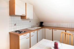 eine Küche mit weißen Schränken, einer Spüle und einem Tisch in der Unterkunft Landhaus Ferk in Bad Radkersburg