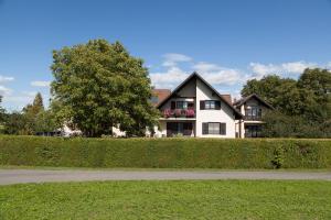 ein großes weißes Haus mit einem Baum davor in der Unterkunft Landhaus Ferk in Bad Radkersburg