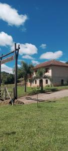 una casa con un letrero en la calle frente a un campo en Casa de Campo Província Minosso, en Farroupilha