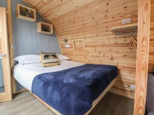 ein Schlafzimmer mit einem Bett in einer Holzhütte in der Unterkunft Ingleborough in Clitheroe