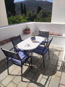 a white table and four chairs on a patio at Estelle in Khalkíon
