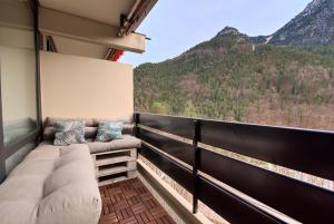 a balcony with a couch and a view of mountains at Me(H)rblick - Pool - Balkon - Panorama in Bad Reichenhall