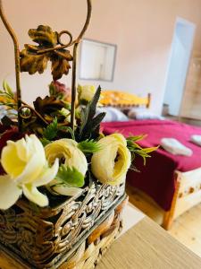 a basket with flowers on a table in a bedroom at Travel Inn House Mestia • მოგზაურის სახლი in Mestia