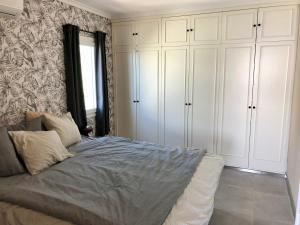 a bedroom with a bed with white cabinets and a window at Atlantic View Maspalomas in Maspalomas +29 photos