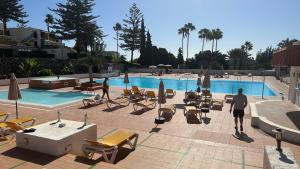 a man standing in front of a swimming pool at Atlantic View Maspalomas in Maspalomas