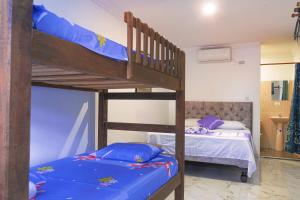 卡利Hotel Orquídea Real的配有蓝色床垫的客房内的2张双层床