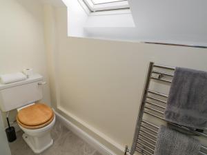a bathroom with a toilet with a wooden seat at The Granary in Southam