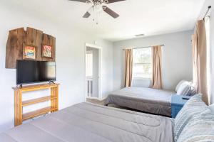 a bedroom with two beds and a flat screen tv at Heights Haven in Tampa