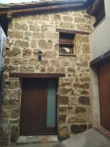 貝塞特的住宿－El Castellá，石头建筑,设有两扇门和一扇窗户