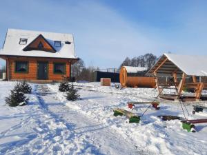 domek z bali i śniegiem na ziemi w obiekcie Domek do wynajęcia - Siedlisko przy lesie w mieście Rząśnik