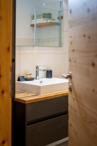 a bathroom with a sink and a mirror at Apartment LENA in Obertilliach