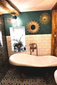een badkamer met een bad en groene muren bij Agroturystyka Rancho Lavender - Dom gościnny 