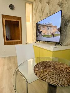 a television sitting on a desk with a glass table at Studio at Synagogue with Sauna in Budapest