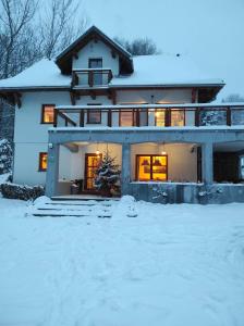 ein Haus mit Schnee auf dem Boden davor in der Unterkunft Gościniec Śliwkula in Jaworzynka