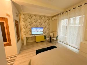 a bedroom with a bed and a television on a wall at Studio at Synagogue with Sauna in Budapest