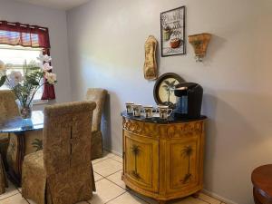 a room with a wooden cabinet and a chair at Professor Rousseau's Palm Paradise in Crystal River