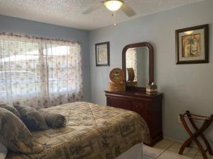 a bedroom with a bed and a dresser and a mirror at Professor Rousseau's Palm Paradise in Crystal River