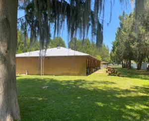 a building with picnic tables in a park with a tree at Professor Rousseau's Palm Paradise in Crystal River