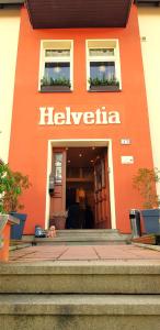 バート・エルスターにあるVilla Helvetiaの琵琶を読む看板のあるオレンジ色の建物