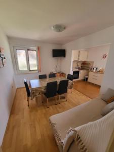 salon ze stołem, krzesłami i kanapą w obiekcie Island Paradise Apartment w mieście Kukljica