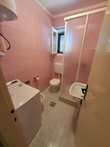 różowa łazienka z toaletą i umywalką w obiekcie Island Paradise Apartment w mieście Kukljica +19 zdjęć