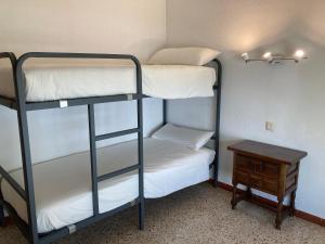 a room with two bunk beds and a table at Apartamento L'Estartit in L'Estartit