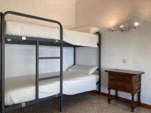 a bunk bed room with two bunk beds and a table at Apartamento L'Estartit in L'Estartit