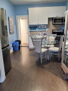 a kitchen with a table and chairs and a refrigerator at Niagara Getaway in Niagara Falls