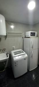 a small kitchen with a microwave on top of a refrigerator at Departamento en Recoleta in Buenos Aires