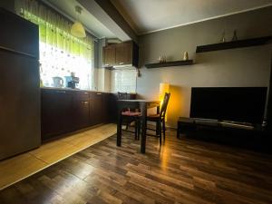 ein Wohnzimmer mit einem Tisch und einem TV in der Unterkunft Prima Residence Apartment in Oradea