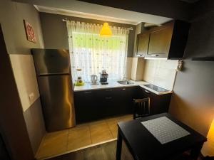 a small kitchen with a refrigerator and a table at Prima Residence Apartment in Oradea