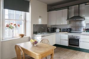 a kitchen with white cabinets and a table with a bowl on it at Smart self-catering apartment, Clitheroe in Clitheroe