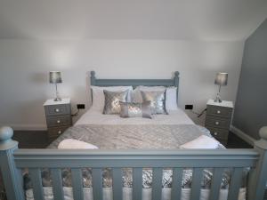 a bedroom with a blue bed with two night stands at SJs Cottage in Coleraine
