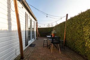 a patio with a table and chairs on the side of a house at 40, Theme Forest world - Dogs allowed! in Oisterwijk