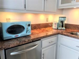 a kitchen with a microwave sitting on a counter at Upscale Mission Beach Couples Getaway/Pet Friendly in San Diego