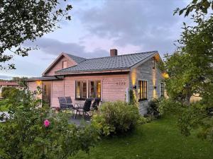 een huis met een tafel en stoelen in de tuin bij Koselig bolig i Lofoten / Vesterålen in Strønstad