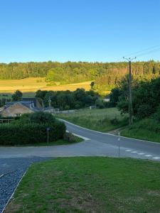a winding road in a field with a farm at La côte du Muret in Fagnon