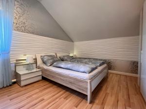 a bedroom with a bed and a wooden floor at A&D Apartment+Ferienwohnung/Elsasser Blick in Bühlertal