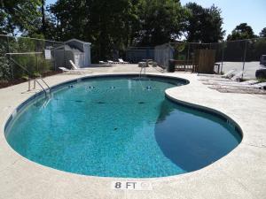 a swimming pool with blue water in a yard at 203D GBR Beautifully Remodeled 4 Bed 3 Bath in Surfside in Myrtle Beach