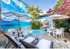 a patio with tables and chairs and a swimming pool at Búzios Casa Verde in Búzios