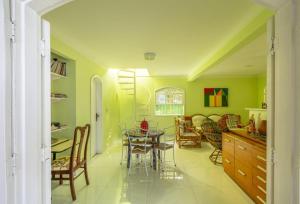 Búzios Casa Verde في بوزيوس: مطبخ وغرفة طعام مع طاولة وكراسي
